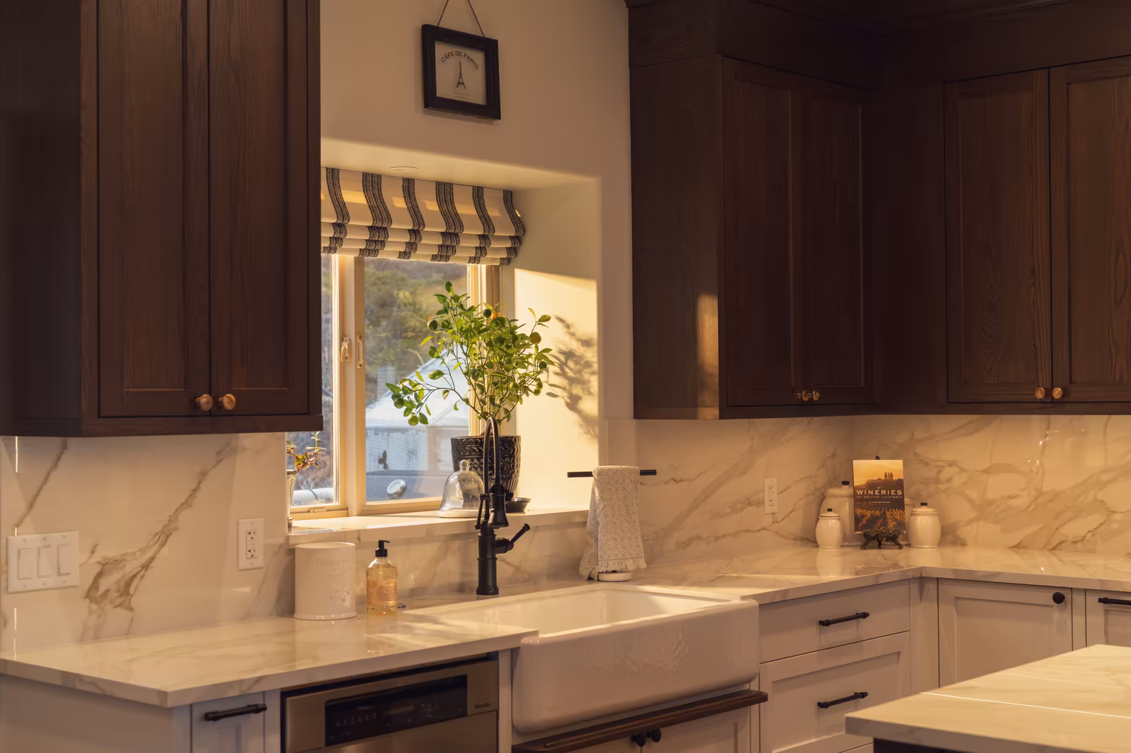 Kitchen cabinetry detail with lighting and a farmhouse sink